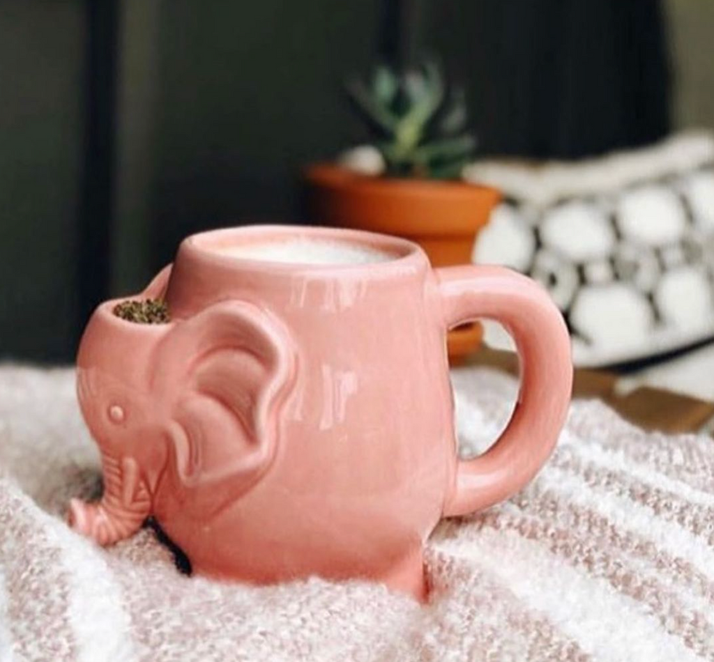 Pink Elephant Mug with a beverage and some herb